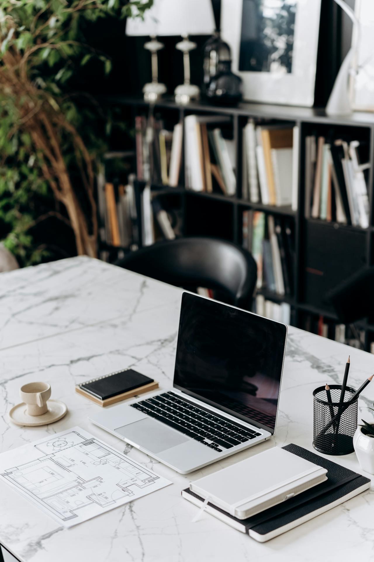 Desk with a laptop and a pen